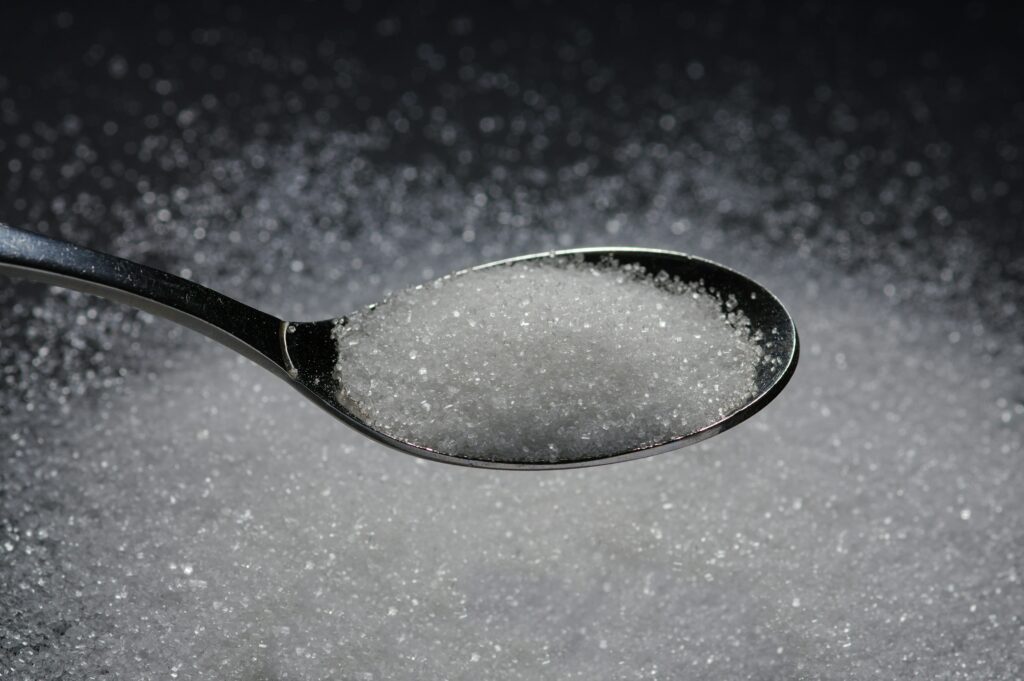 Cuillère de sucre sur fond flou