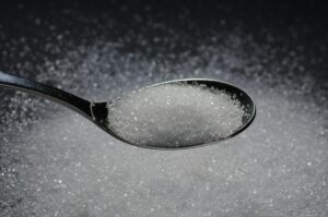 Cuillère de sucre sur fond flou