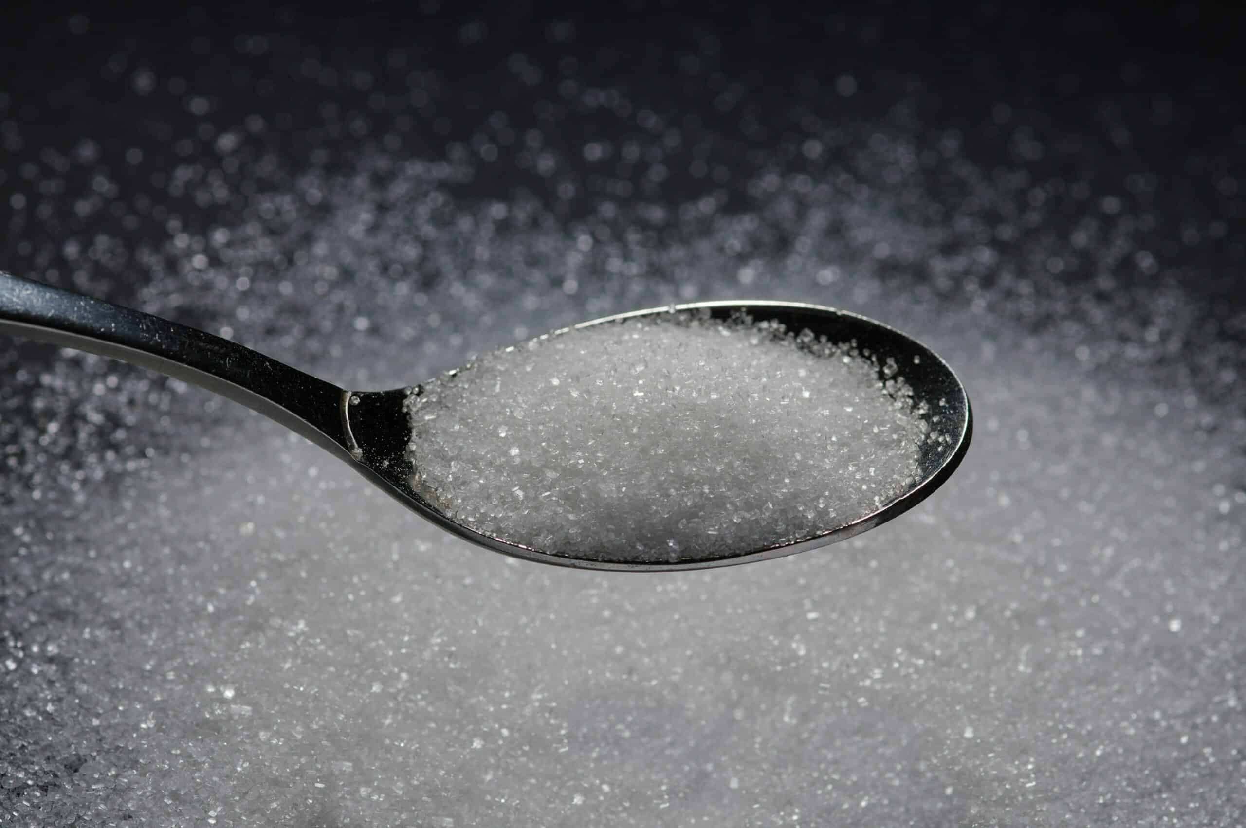 Cuillère de sucre sur fond flou